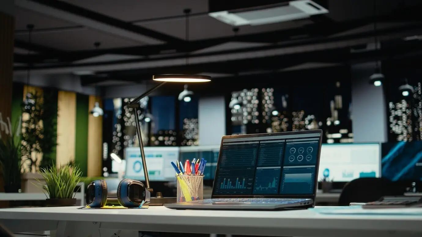 Espace de bureau moderne et luxueux, avec un ordinateur portable sur un bureau vide affichant des rapports importants et mettant en évidence des données importantes.